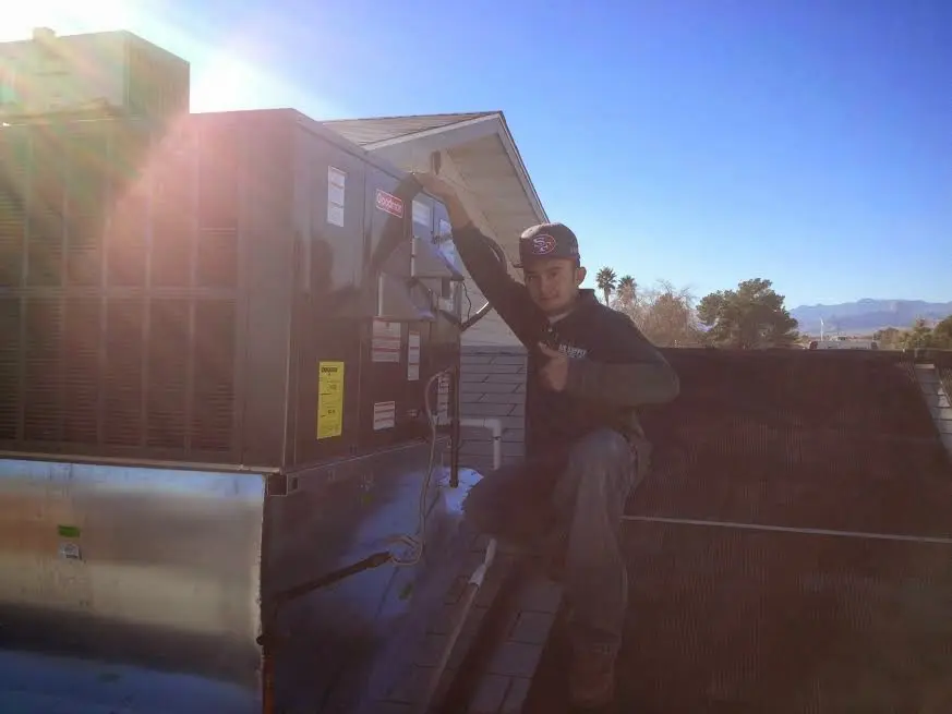 HVAC technician performing AC Tune-Up on a rooftop unit in Crystal City